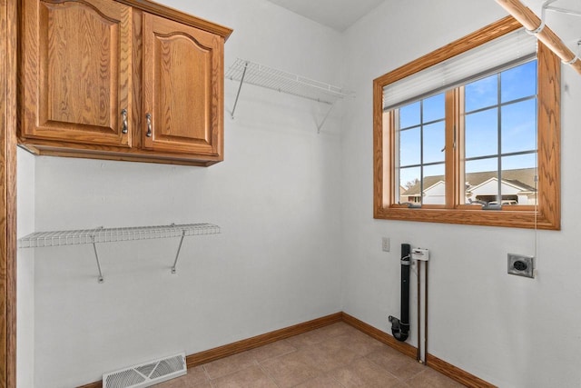 clothes washing area with cabinets and hookup for an electric dryer