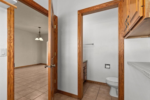 bathroom featuring toilet, an inviting chandelier, tile patterned floors, and vanity