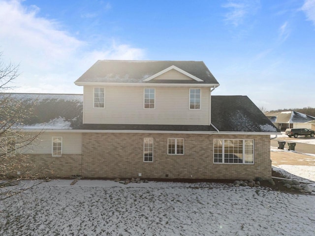 view of snow covered back of property