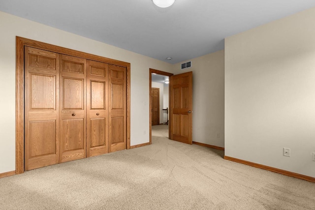 unfurnished bedroom with light carpet and a closet