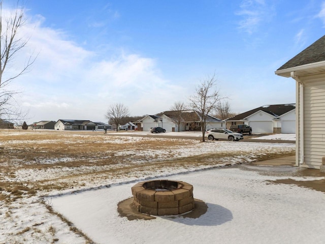 yard layered in snow with an outdoor fire pit