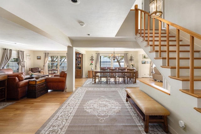 interior space featuring plenty of natural light, an inviting chandelier, and light wood-type flooring