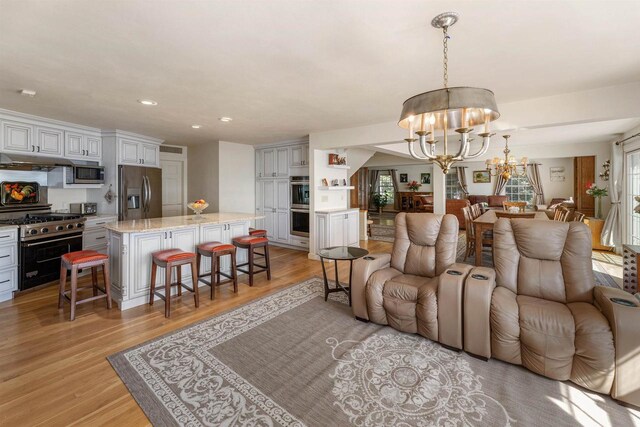 living room with a chandelier and light hardwood / wood-style flooring