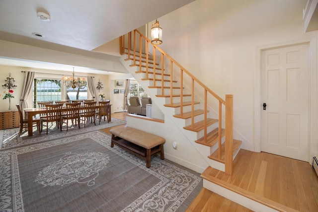 stairway with an inviting chandelier and hardwood / wood-style floors