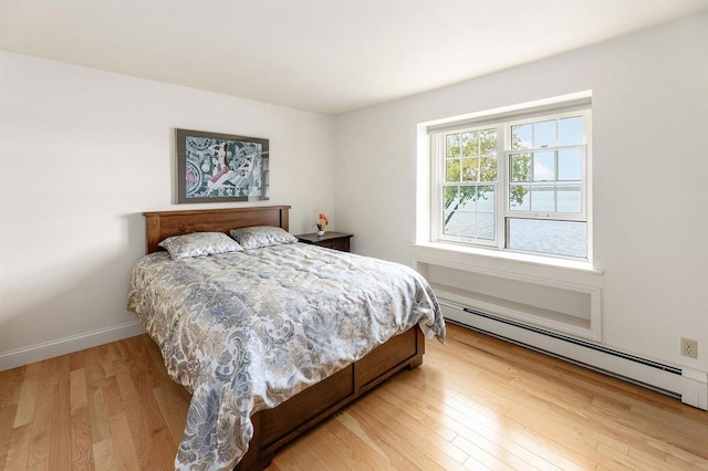 bedroom with hardwood / wood-style flooring and a baseboard radiator