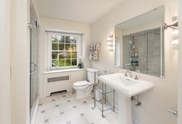 bathroom with a shower with shower door, toilet, and radiator heating unit