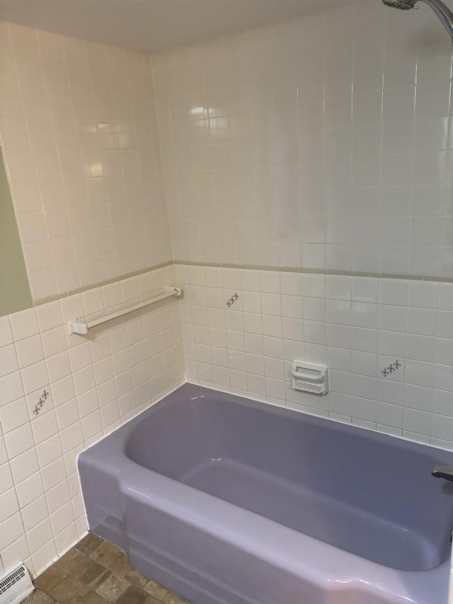 bathroom featuring a baseboard radiator and tile walls