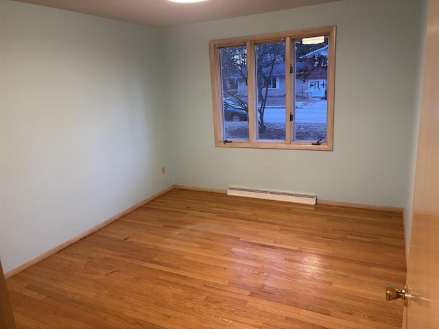 empty room featuring light wood-type flooring and baseboard heating