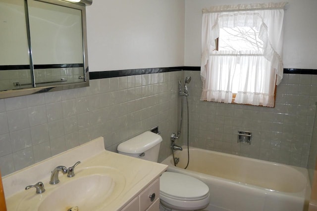 bathroom with toilet, vanity, tile walls, and a wealth of natural light