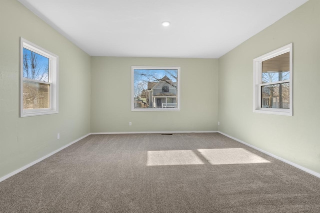 empty room featuring carpet flooring and plenty of natural light