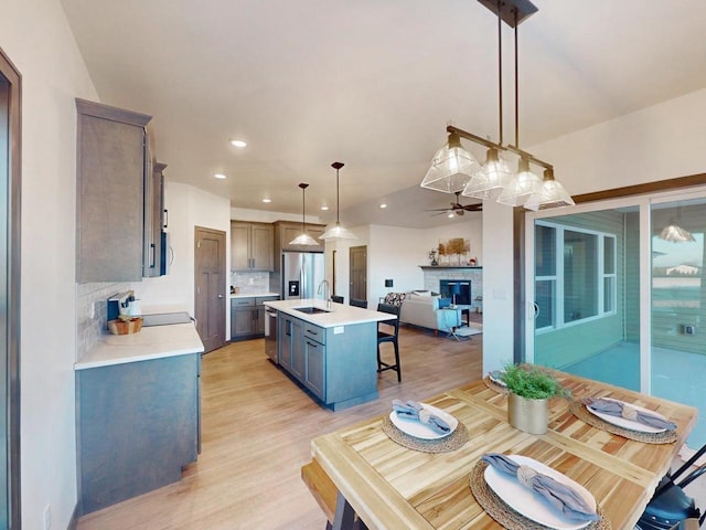 dining area with sink, ceiling fan, and light hardwood / wood-style flooring