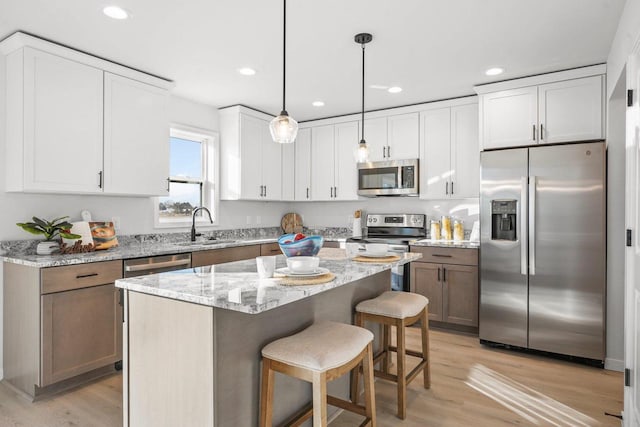 kitchen featuring white cabinets, stainless steel appliances, and a kitchen island