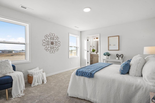 bedroom with light colored carpet and ensuite bath