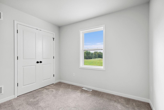 unfurnished bedroom with a closet and carpet flooring