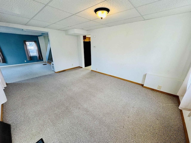 carpeted empty room with a drop ceiling