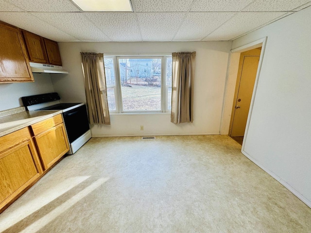 kitchen with electric range, a paneled ceiling, and light carpet