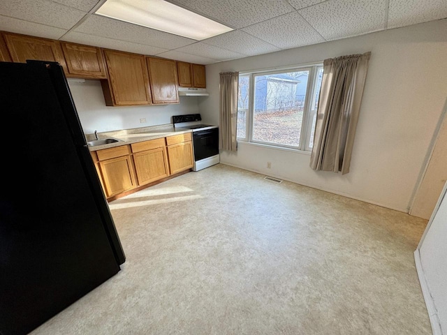 kitchen with black fridge, a paneled ceiling, white electric range oven, and sink