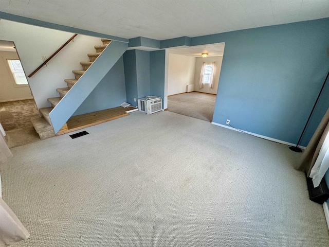 unfurnished living room featuring carpet and a healthy amount of sunlight