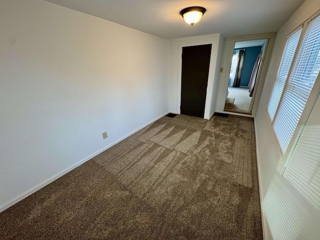 carpeted empty room featuring a textured ceiling