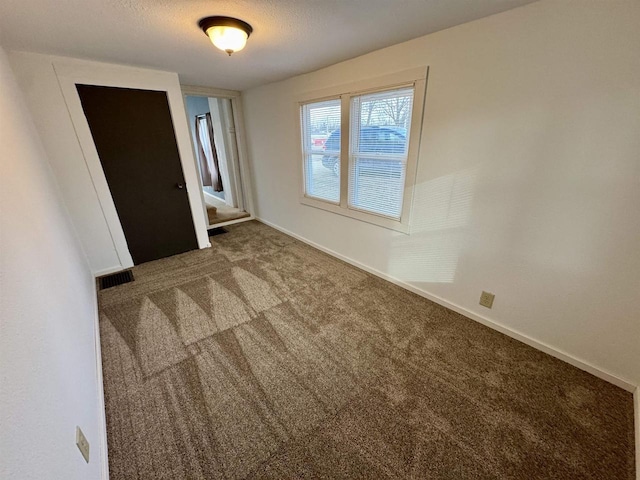 carpeted spare room featuring a textured ceiling