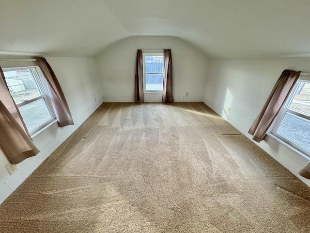 additional living space featuring lofted ceiling and light colored carpet