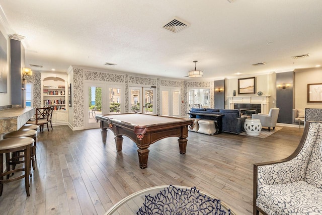 playroom with french doors, ornamental molding, hardwood / wood-style flooring, and built in shelves