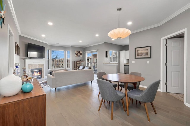 dining area featuring light hardwood / wood-style flooring and ornamental molding