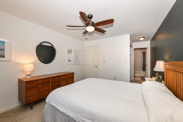 carpeted bedroom with ensuite bathroom and ceiling fan