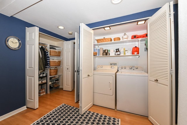 laundry room featuring washing machine and dryer and light hardwood / wood-style flooring