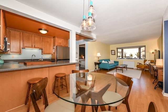 dining area with sink, light hardwood / wood-style flooring, and radiator heating unit