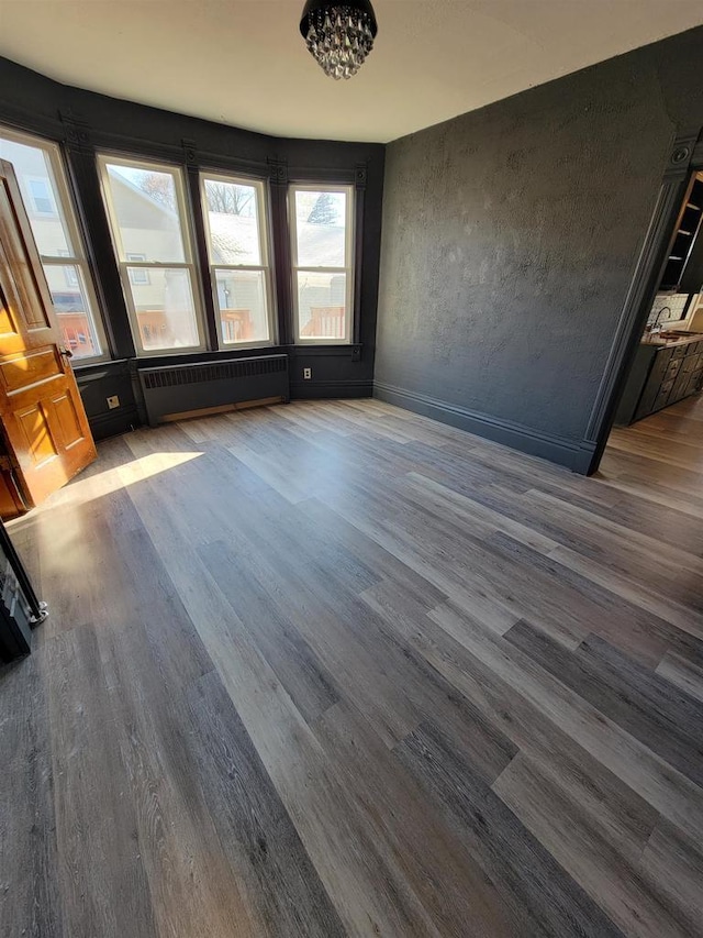 interior space with radiator heating unit and hardwood / wood-style flooring