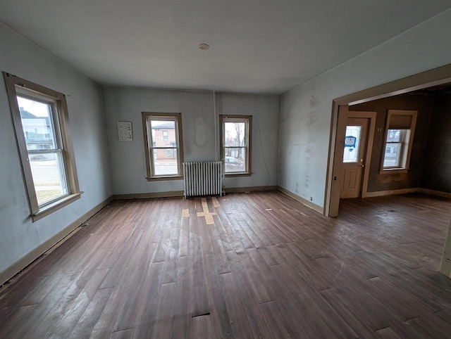 empty room featuring radiator and dark hardwood / wood-style flooring