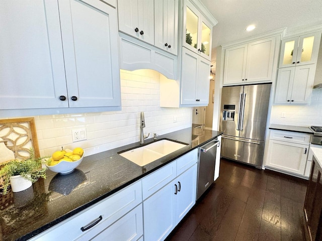 kitchen featuring backsplash, dark stone countertops, white cabinetry, stainless steel appliances, and dark hardwood / wood-style flooring