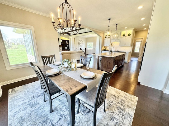 dining area with an inviting chandelier, ornamental molding, dark hardwood / wood-style floors, and sink