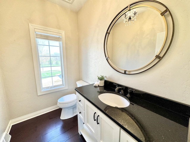 bathroom with hardwood / wood-style flooring, toilet, vanity, and a notable chandelier