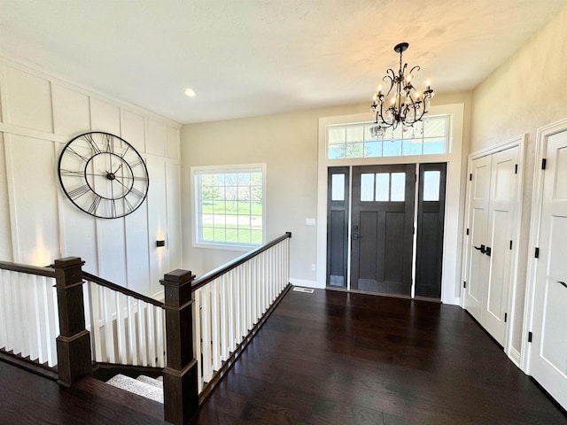 entryway with a chandelier and dark hardwood / wood-style floors