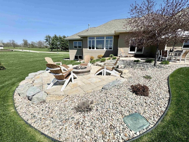 back of property featuring a yard, a patio area, and a fire pit