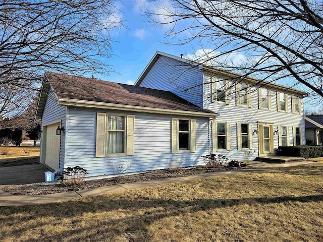 back of house featuring a garage and a yard