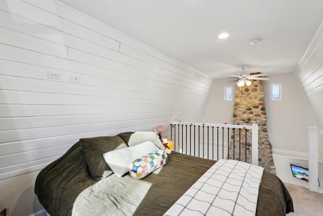 bedroom with carpet floors, wooden walls, and ceiling fan