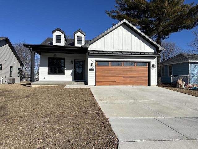 view of front of home with covered porch, cooling unit, and a garage