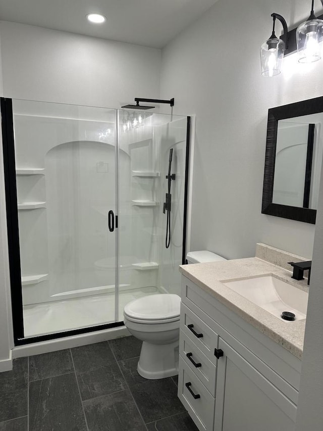 bathroom with an enclosed shower, vanity, tile patterned floors, and toilet