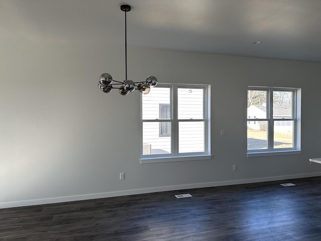 unfurnished room featuring dark hardwood / wood-style flooring and a chandelier