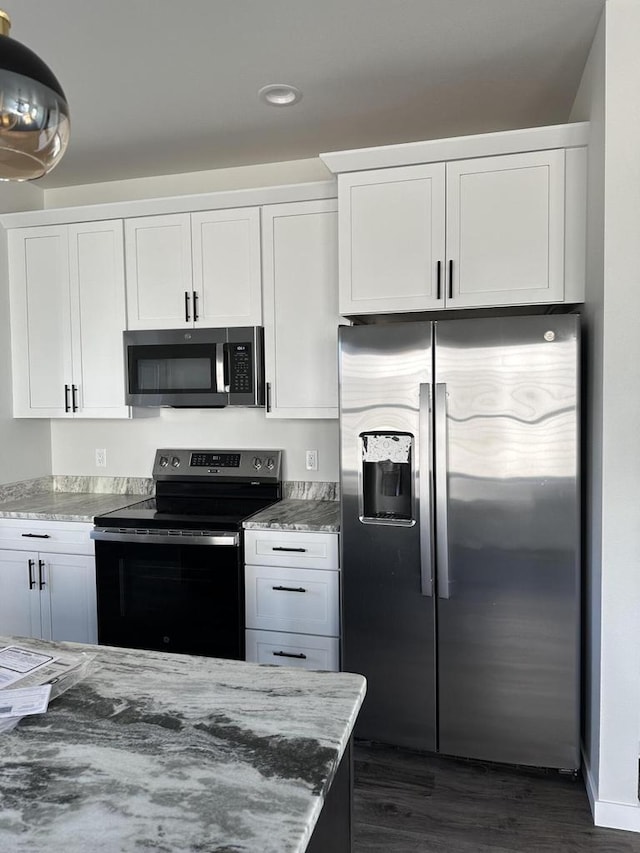 kitchen featuring light stone counters, dark wood-type flooring, white cabinets, and stainless steel appliances