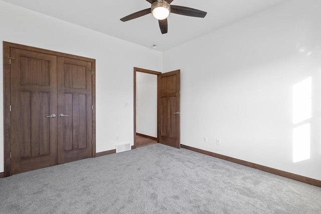 unfurnished bedroom with carpet, a closet, and ceiling fan