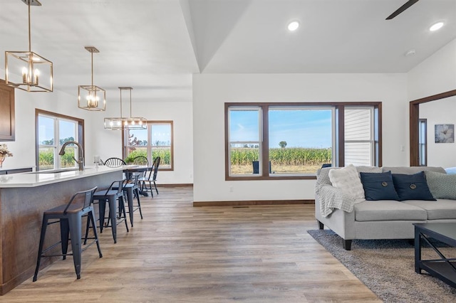 living room featuring sink, light hardwood / wood-style floors, and a chandelier