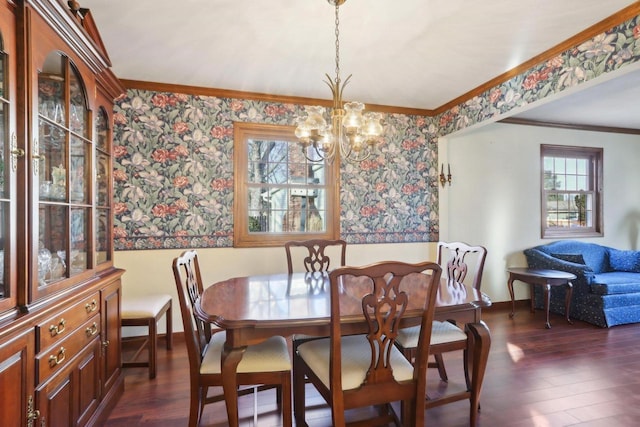 dining room featuring dark wood-type flooring, ornamental molding, and an inviting chandelier