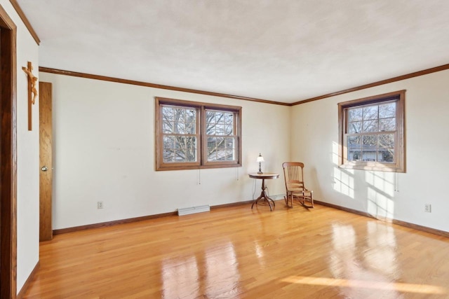 empty room featuring light wood-type flooring and ornamental molding