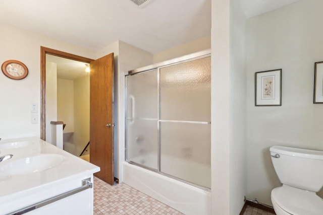 full bathroom featuring enclosed tub / shower combo, vanity, and toilet