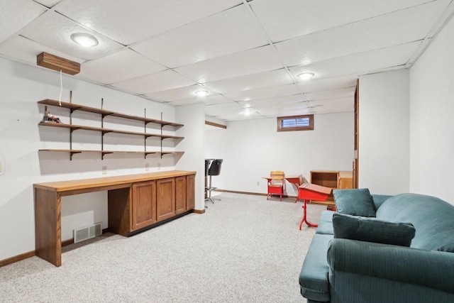 interior space featuring built in desk and a paneled ceiling