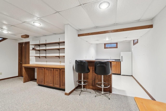 kitchen featuring white fridge, a paneled ceiling, and light carpet